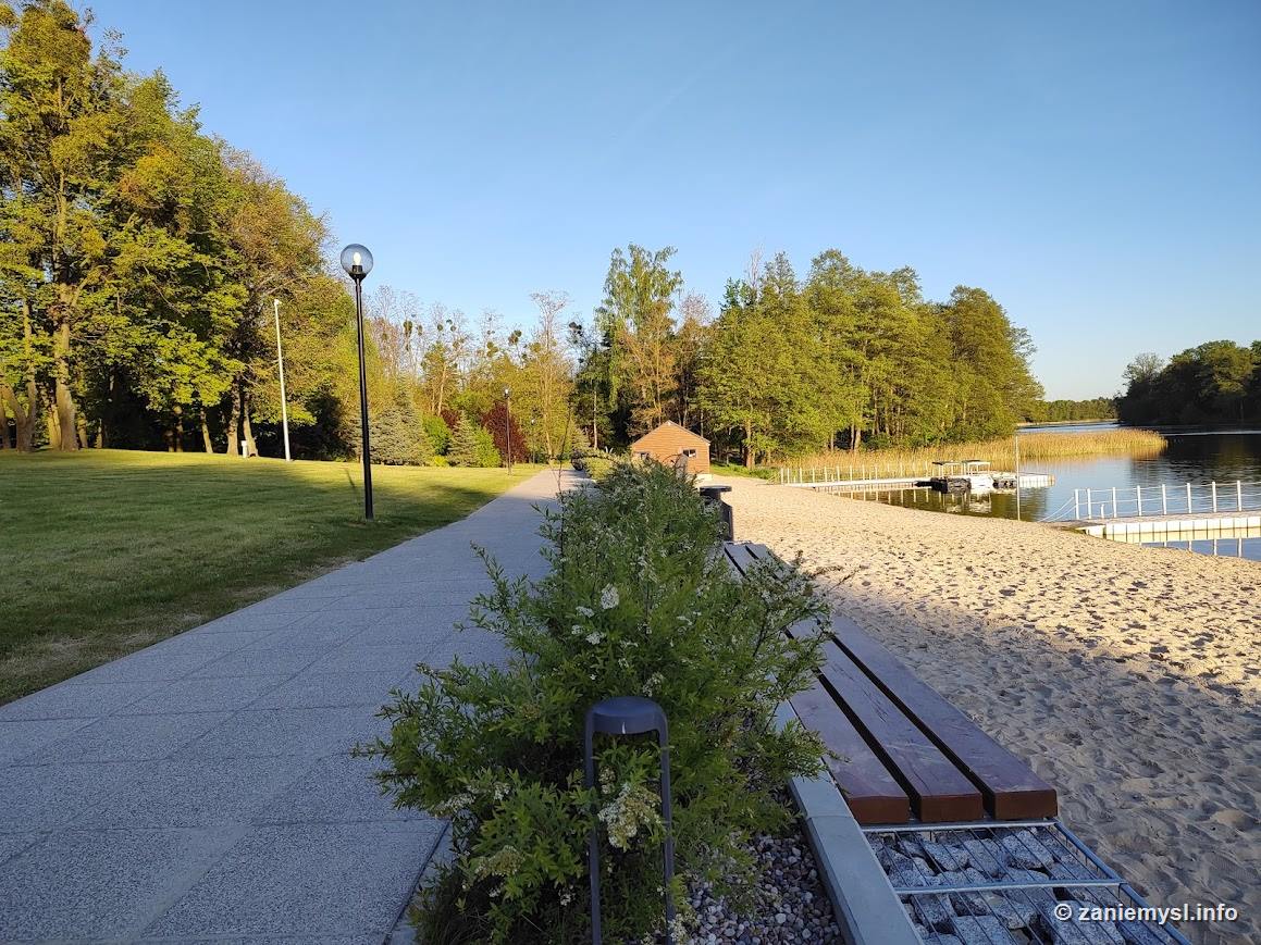 Promenada nad jeziorem w promieniach zachodzącego słońca